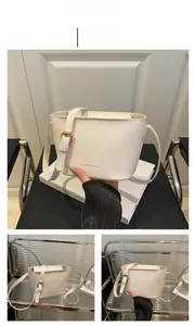 Detail view of white bucket bag featuring litchi grain texture and gold metal buckle