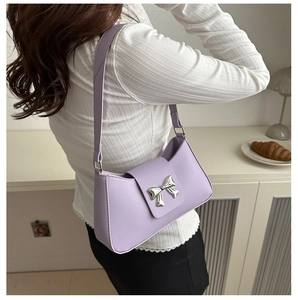 Chic lavender underarm bag with a silver bow clasp shown on model in a soft minimalist setting