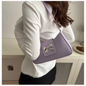 Detail of light purple leather baguette bag with a silver metallic butterfly clasp accent