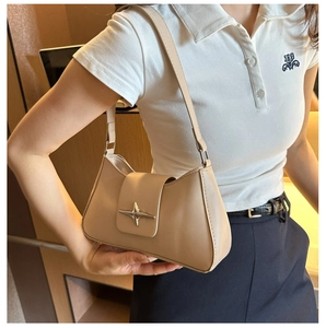 Detail of nude underarm bag featuring silver star metal buckle and smooth matte texture
