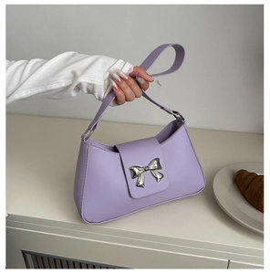 Detail of lavender shoulder bag with silver bow ornament and leather texture