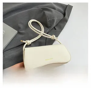 Close-up of white litchi grain texture and thick rope strap with gold metal caps