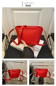 Detailed view of red bucket bag showing pebbled leather texture and embossed logo