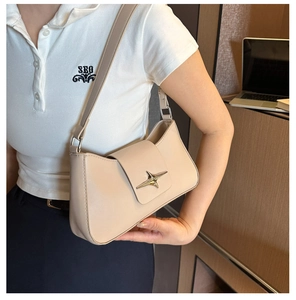 Close-up of star-shaped metal buckle on cream faux leather underarm bag for women