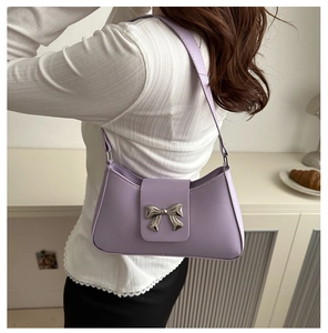 Close-up of lavender shoulder bag featuring a silver bow-knot metal clasp detail