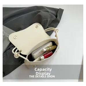 Detail showing inner capacity of the cream faux leather bag with magnetic buckle
