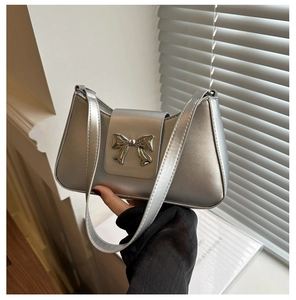 Detail shot of the metallic silver underarm bag with a stylish bow metal buckle