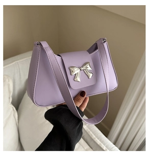 Detail of lavender shoulder bag featuring a silver butterfly buckle and matte leather