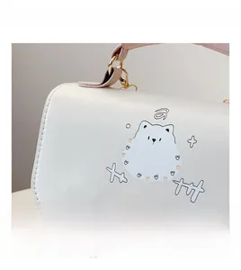 Gros plan du cuir PU à motif litchi sur un petit sac bandoulière avec motif chiot mignon