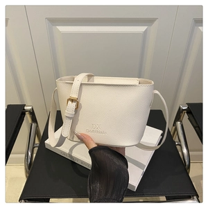 Close-up of a white lychee grain leather crossbody bag with golden hardware and brand logo