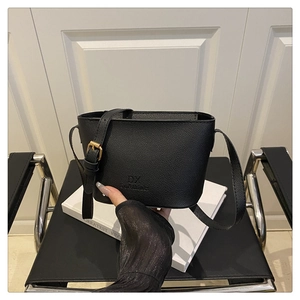 Detailed close-up of black lychee grain leather bucket bag with gold hardware buckle