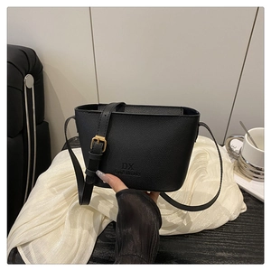 Detail of black lychee grain leather bucket bag with gold buckle and brand logo