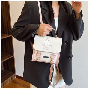 Détail d'un mini sac à dos avec imprimé chat mignon et poignée rose contrastante