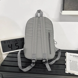 Minimalist grey nylon backpack back view with adjustable straps and side zipper pocket