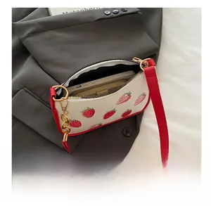 Detail showing internal capacity of strawberry print handbag with phone and wallet