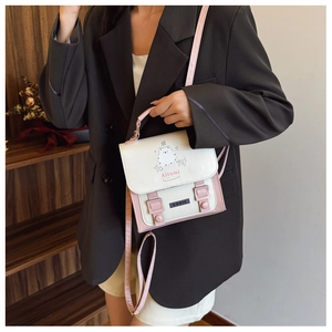 Detail of pink and white PU leather crossbody bag with cute cat print and top handle