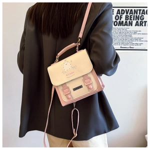 Détail d'un sac à dos rose et blanc en similicuir avec motif ours et sangle réglable
