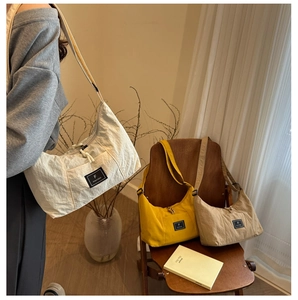 Hobo shoulder bag in beige, yellow, and khaki with woven fabric and zipper closure