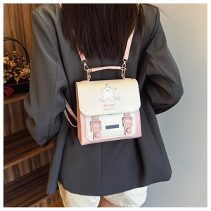 Vue de dos d'une femme portant un mini sac à dos crème et rose à motif chaton