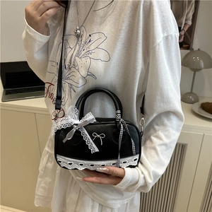 Chic black PU leather Boston bag with white lace trim and bow knot detail on model