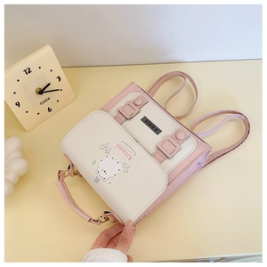 Detail of a pink and white mini backpack with a cat pattern and top handle on a yellow desk