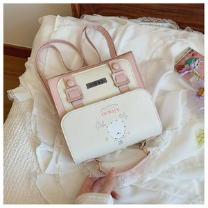 Detail of a pink and white crossbody bag with a cute cartoon bear and a small top handle