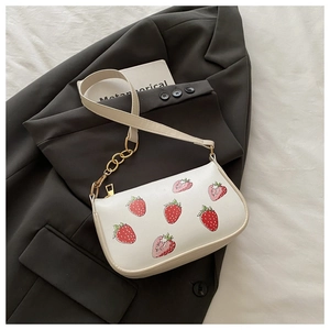 Nahaufnahme der Erdbeer-Lederhandtasche mit Goldkette und Reißverschluss auf einem Blazer