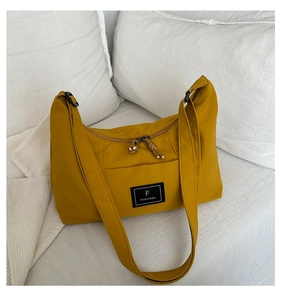 Detail of ginger yellow half-moon hobo bag showing fabric texture and FANYISSA label