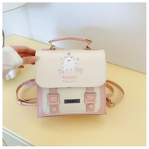 Close-up of pink and cream mini handbag with cute cartoon dog print and strap buckles