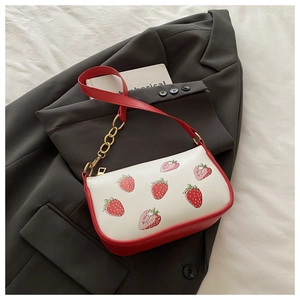 Detail der roten Erdbeer-Print-PU-Tasche mit cremefarbenem Leder und goldener Kette