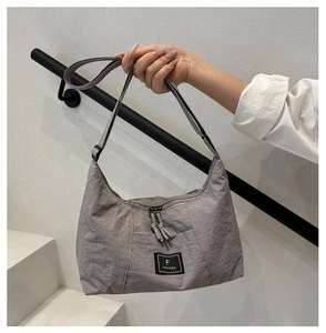 Close-up of grey nylon hobo bag with black F FANVISSA logo and adjustable strap