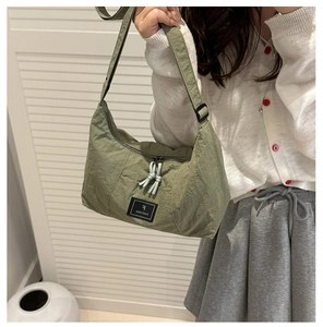 Detail of army green nylon hobo bag showing fabric texture and adjustable shoulder strap