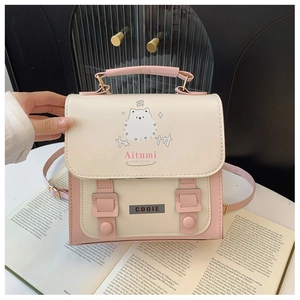 Detail of a pink and white crossbody bag with cute cartoon prints and shoulder strap