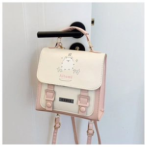 Detail of pink and beige cute school backpack featuring cartoon dog pattern on a door