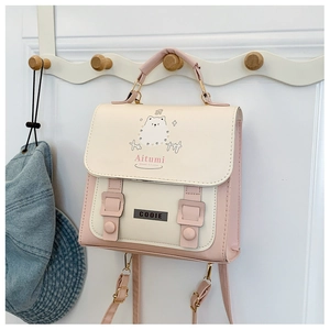 Détail du sac bandoulière rose et crème avec illustration de chat et boucles en métal
