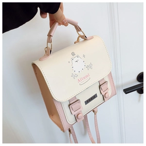 Detailed shot of pink and white crossbody bag with cute cat illustration and gold hardware