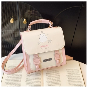 Detail of a pink and white leather mini backpack featuring a cute cartoon bear illustration