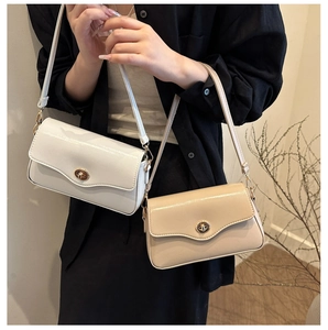 Détail de sacs bandoulière en cuir verni avec rabat ondulé et fermoir rotatif doré