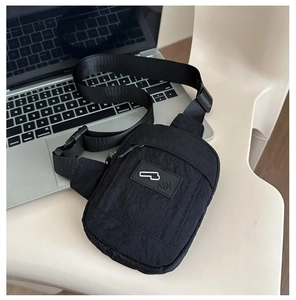Gros plan détaillé d'un sac de poitrine en nylon noir avec logo et poche avant zippée