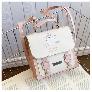 Detail of a pink and cream PU leather backpack featuring cute cartoon graphics and buckles
