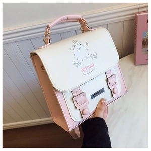 Detail of pink and cream flap handbag featuring a cartoon animal print and top handle