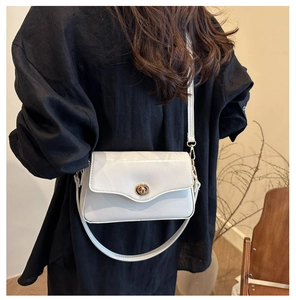 Détail du sac bandoulière en cuir PU blanc avec fermoir tournant en métal doré ovale