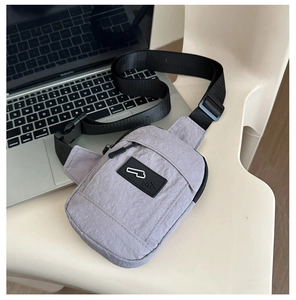 Détail du sac de poitrine en nylon lilas avec logo en caoutchouc et sangle ajustable