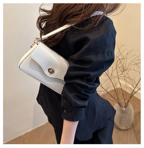 Détail du sac baguette blanc minimaliste avec fermoir rotatif doré et texture en cuir PU