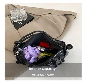Internal capacity of black sequin shoulder bag with essentials like lipstick and phone