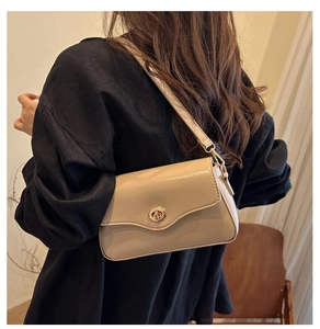 Détail du sac bandoulière en cuir verni beige avec fermoir doré et bandoulière réglable