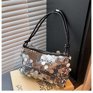 Close-up of silver oversized sequins on a stylish shoulder bag with metallic textures