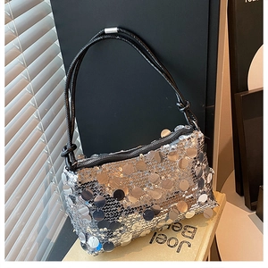 Close-up of silver sequin handbag with round mirror accents and black knotted straps
