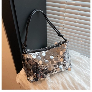 Detailed view of silver sequin bag with black rope shoulder strap and metal zipper