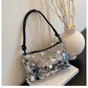 Detail of silver sequin shoulder bag with black braided rope handle and zip closure